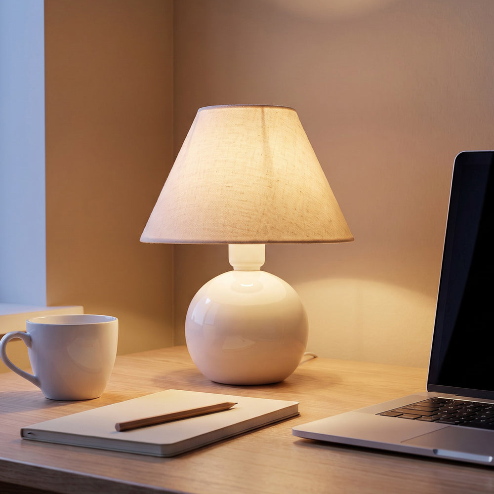Abajur bolinha branco com cúpula de tecido aceso na escrivaninha de home office #branco #tecido