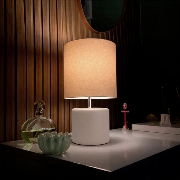 Abajur cilindro de cerâmica off white aceso no ambiente, cúpula de tecido Pratelar #offwhite
