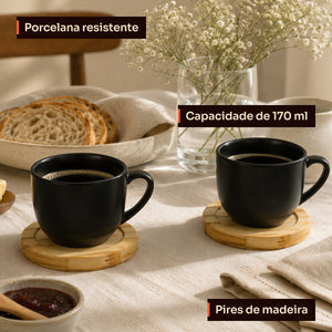 Xícaras pretas de porcelana com pires de madeira na mesa do café