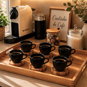 Xícara de porcelana preta com café e pires de pinus