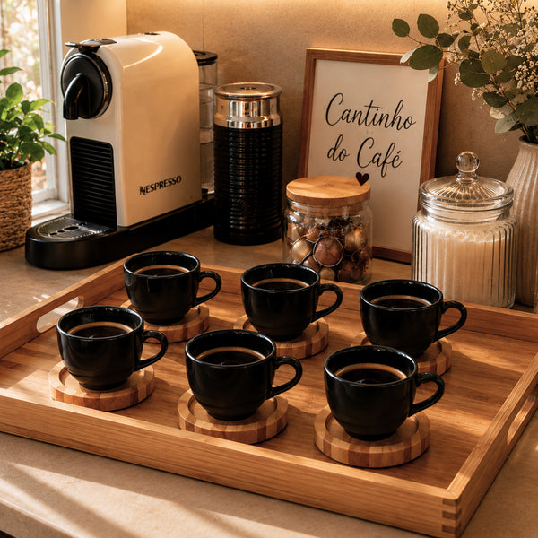 Xícara de porcelana preta com café e pires de pinus